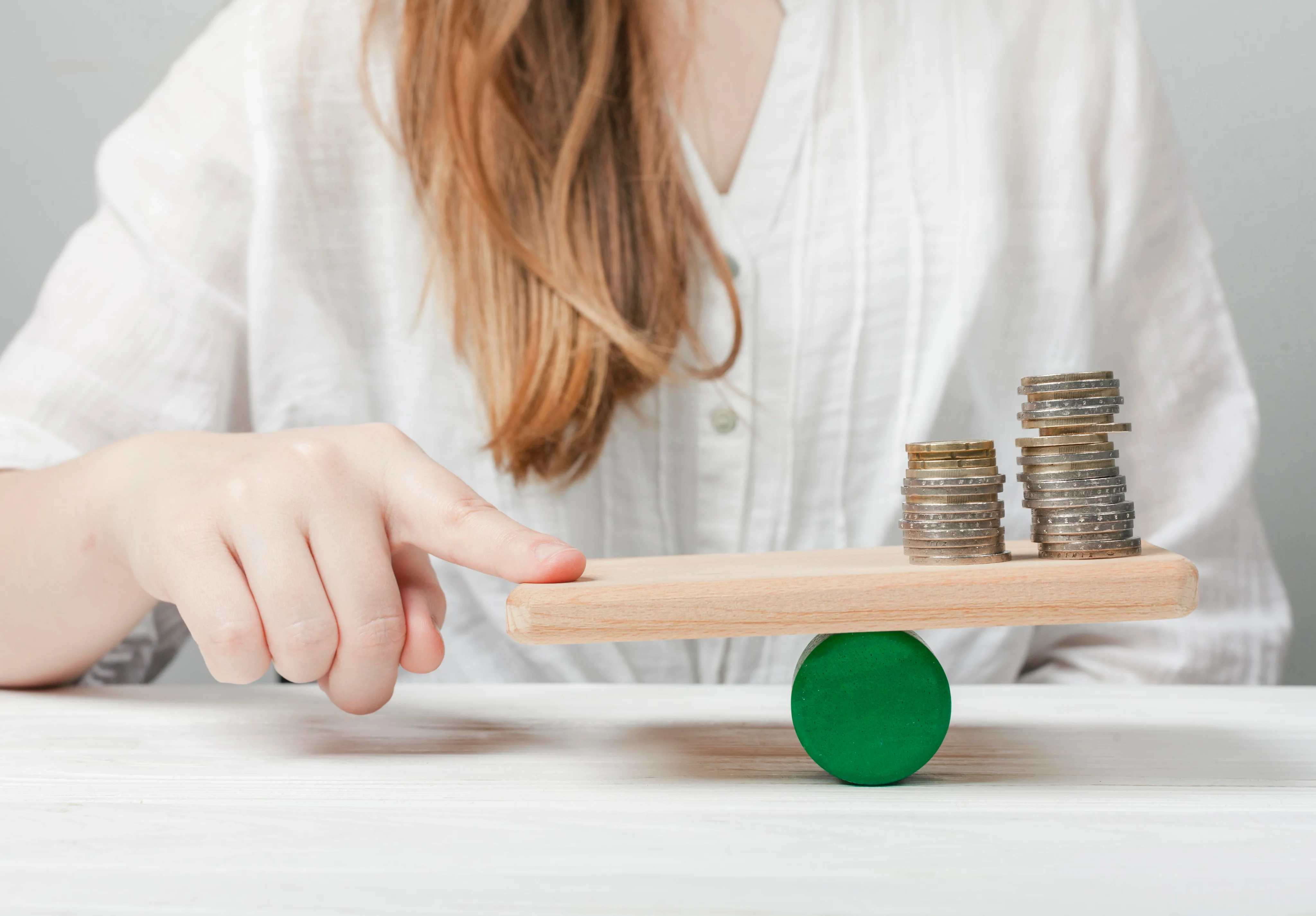 Hands balancing coins representing reliable income